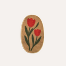 Oval-shaped woven mat with red tulip design on a beige background